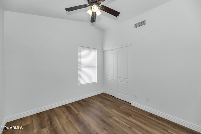 empty room with ceiling fan, dark hardwood / wood-style flooring, and lofted ceiling