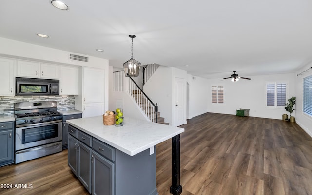 kitchen featuring a center island, pendant lighting, stainless steel gas stove, dark hardwood / wood-style floors, and white cabinetry