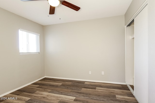 unfurnished bedroom with a closet, ceiling fan, and dark wood-type flooring