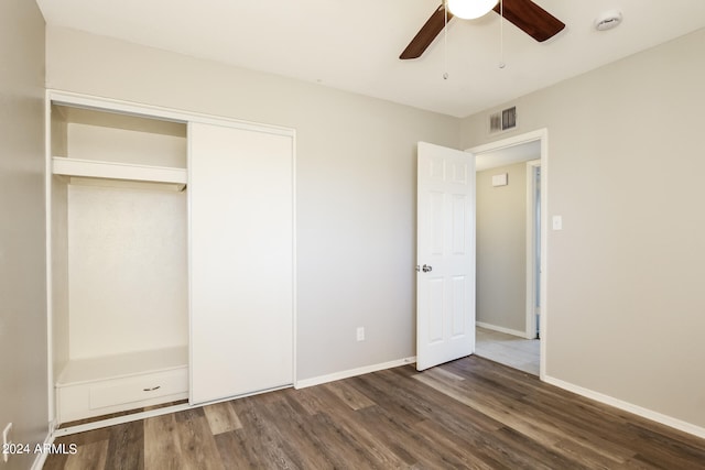 unfurnished bedroom with a closet, ceiling fan, and dark wood-type flooring