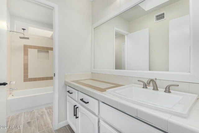 unfurnished bedroom with light colored carpet, a closet, connected bathroom, and ceiling fan