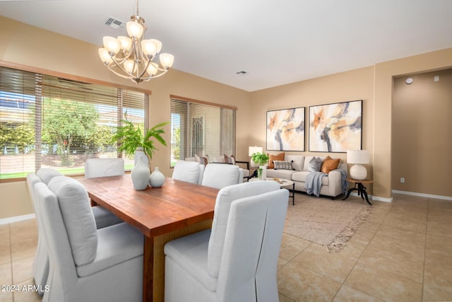 dining space featuring light tile patterned flooring, visible vents, baseboards, and a chandelier