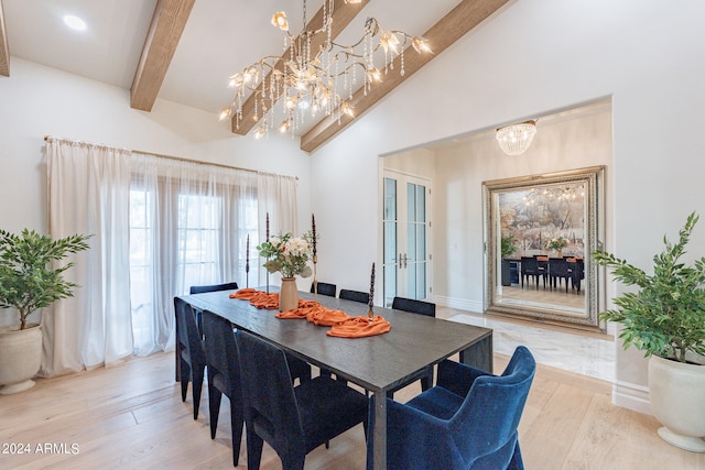 dining room with a notable chandelier, beam ceiling, and light hardwood / wood-style flooring