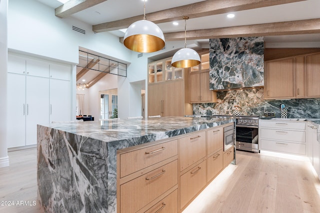 kitchen featuring pendant lighting, dark stone counters, light hardwood / wood-style flooring, backsplash, and vaulted ceiling with beams