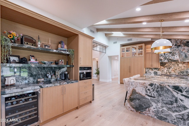 kitchen featuring light brown cabinetry, beverage cooler, hanging light fixtures, and light hardwood / wood-style floors