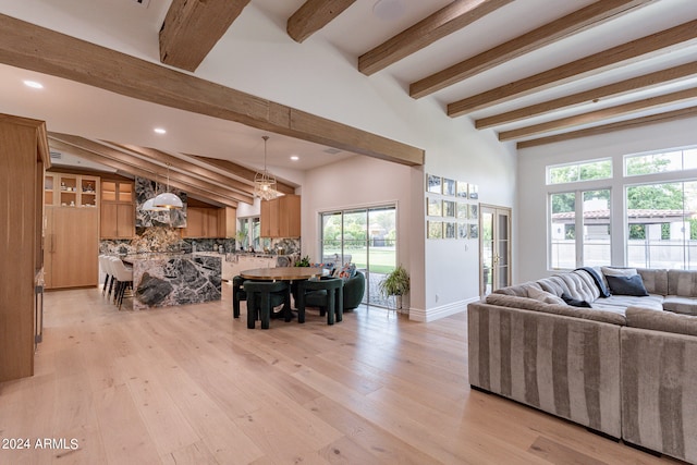 living room featuring light hardwood / wood-style floors and vaulted ceiling with beams