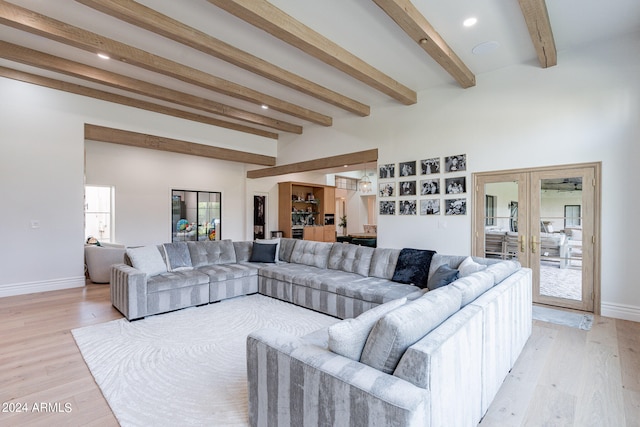 living room featuring french doors, beamed ceiling, and light wood-type flooring