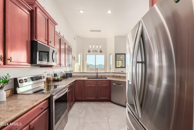 kitchen with sink, stainless steel appliances, and decorative light fixtures