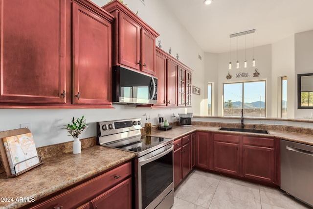 kitchen featuring a mountain view, sink, stainless steel appliances, and decorative light fixtures