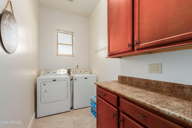 laundry area with cabinets, light tile patterned floors, and washer and clothes dryer