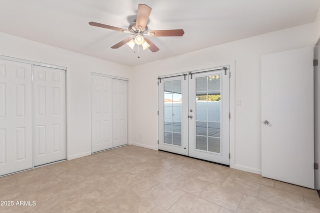 unfurnished bedroom with french doors, access to outside, ceiling fan, and multiple closets