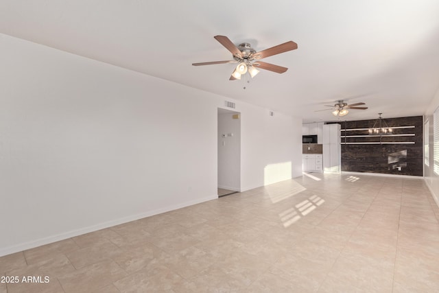 unfurnished living room with ceiling fan with notable chandelier