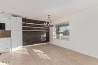 unfurnished living room featuring an inviting chandelier