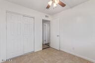 unfurnished bedroom with ceiling fan and a closet