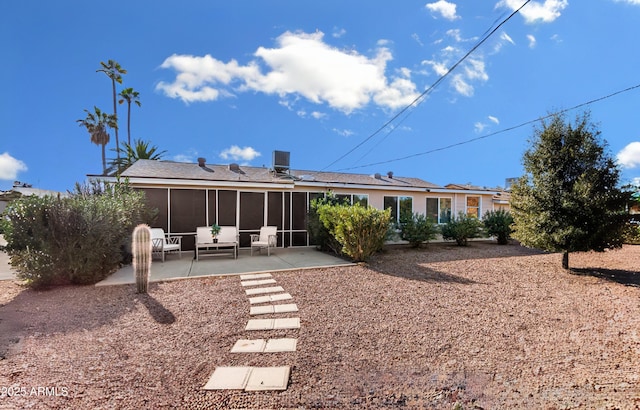 rear view of property with a sunroom and a patio