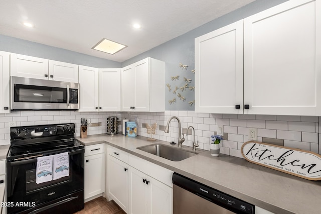 kitchen featuring sink, hardwood / wood-style flooring, white cabinetry, backsplash, and stainless steel appliances