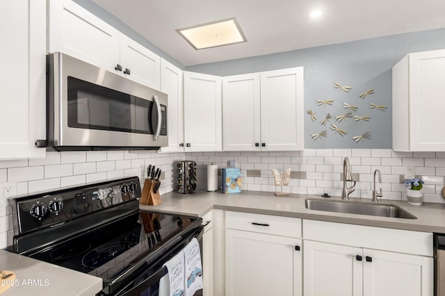 kitchen with white cabinetry, sink, tasteful backsplash, and stainless steel appliances