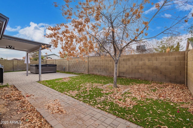 view of yard with a hot tub and a patio area