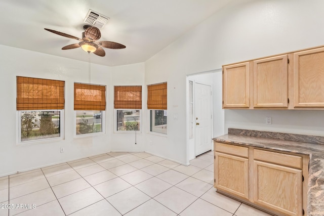 kitchen with vaulted ceiling, ceiling fan, light tile patterned floors, and light brown cabinets