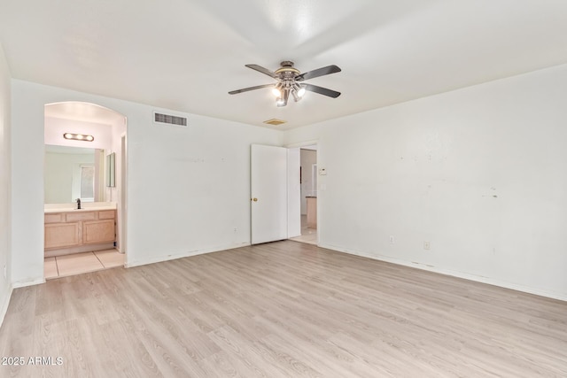 unfurnished bedroom with ensuite bathroom, light hardwood / wood-style floors, and sink