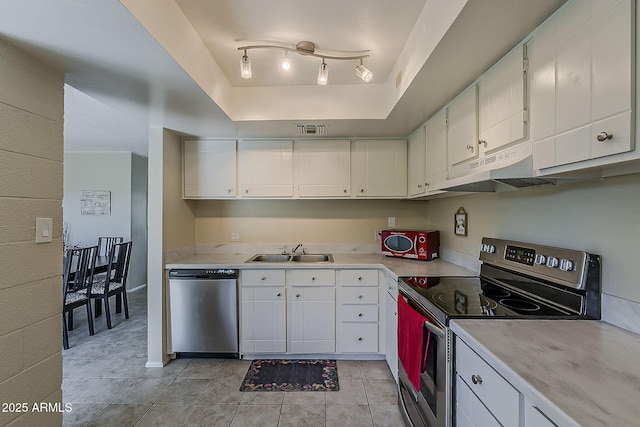 4201 E Camelback Rd Unit 74, Phoenix, AZ 85018 - kitchen with appliances with stainless steel finishes, under cabinet range hood, light tile patterned flooring, light countertops, and white cabinetry