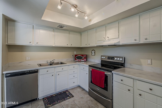 4201 E Camelback Rd Unit 74, Phoenix, AZ 85018 - kitchen featuring stainless steel appliances, under cabinet range hood, light countertops, light tile patterned flooring, and white cabinetry