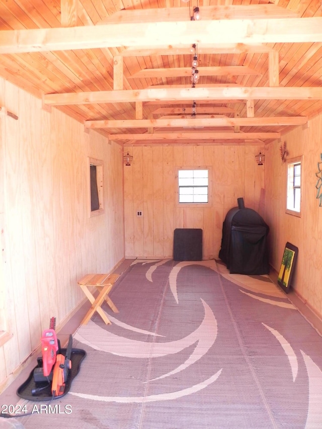 interior space with wooden ceiling, beamed ceiling, and wood walls