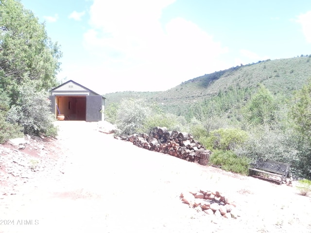 view of shed with a mountain view and a view of trees