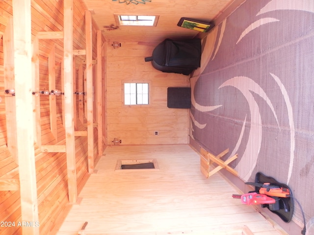 hall with wood walls and hardwood / wood-style flooring