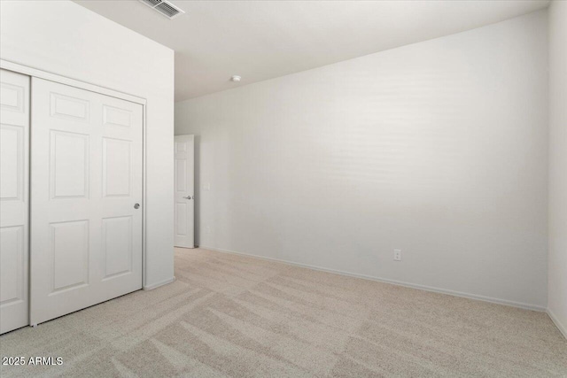 unfurnished bedroom with a closet and light carpet