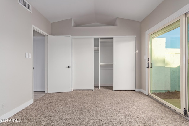 unfurnished bedroom featuring access to exterior, lofted ceiling, a closet, and carpet