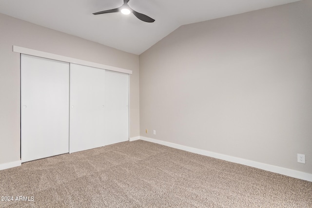 unfurnished bedroom featuring carpet floors, lofted ceiling, a closet, and ceiling fan