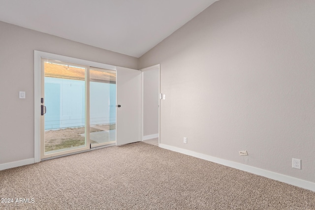 spare room featuring carpet floors, lofted ceiling, and plenty of natural light