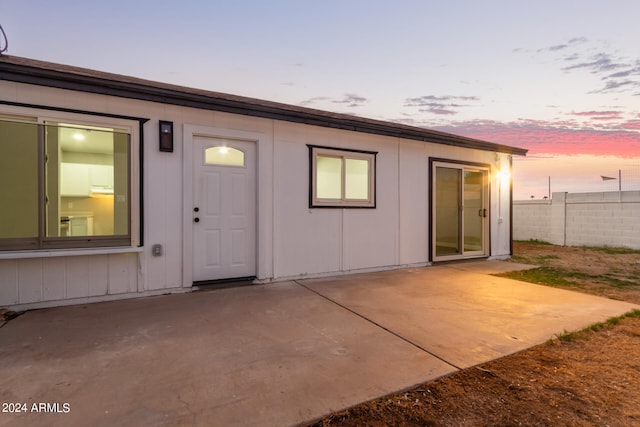 exterior entry at dusk featuring a patio