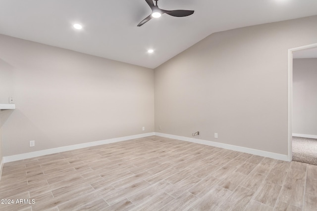 spare room featuring light wood-type flooring, ceiling fan, and vaulted ceiling