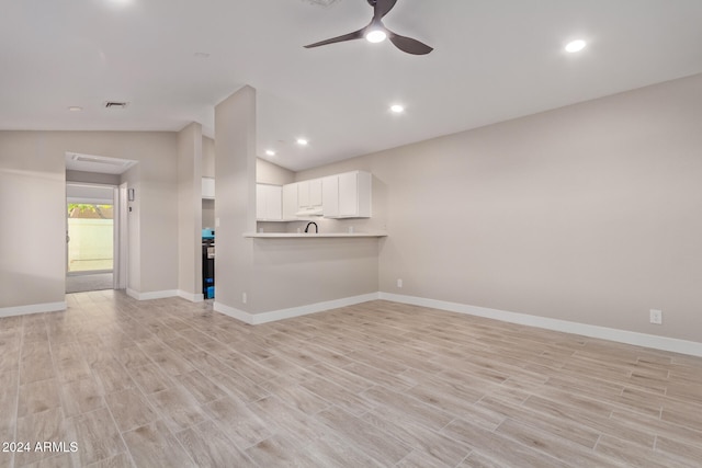 unfurnished living room with light wood-type flooring, ceiling fan, and vaulted ceiling