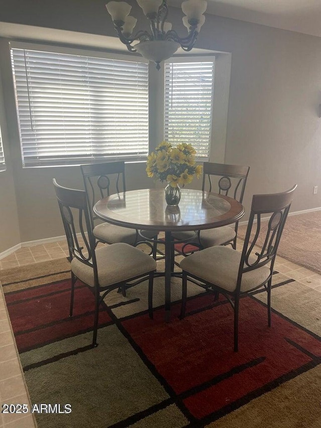 carpeted dining room with an inviting chandelier