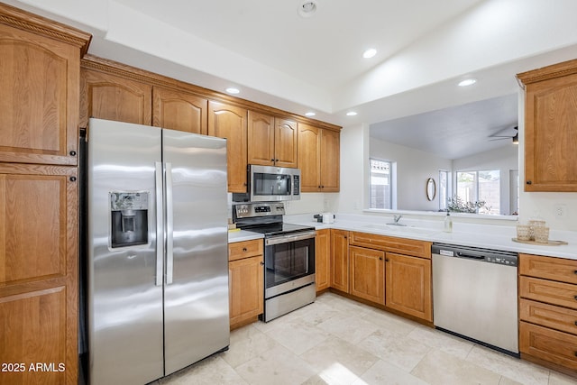 kitchen with appliances with stainless steel finishes, sink, and lofted ceiling