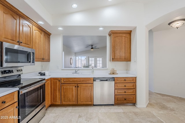 kitchen featuring ceiling fan, sink, stainless steel appliances, and vaulted ceiling