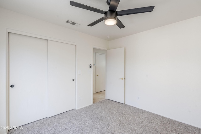 unfurnished bedroom with light carpet, ceiling fan, and a closet