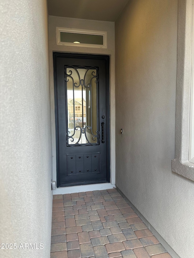 property entrance with stucco siding