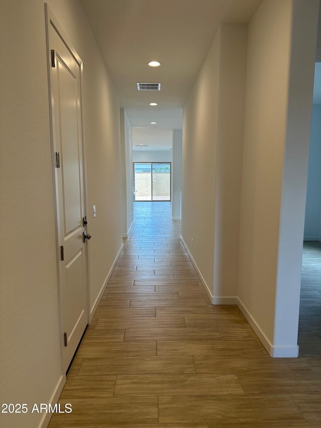hallway with light wood-style flooring, baseboards, and recessed lighting