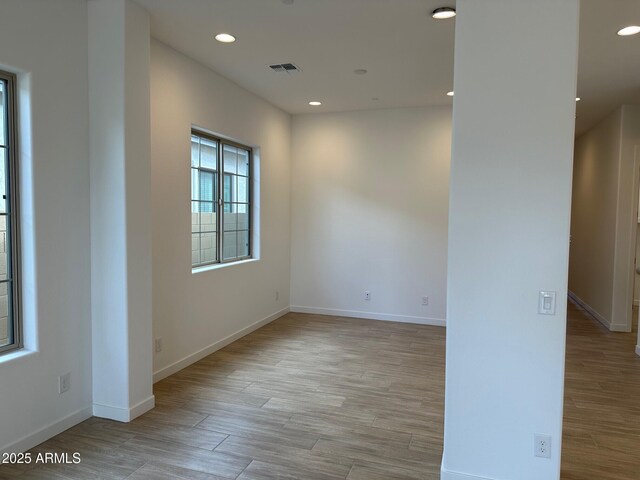 unfurnished room with wood finished floors, baseboards, and recessed lighting