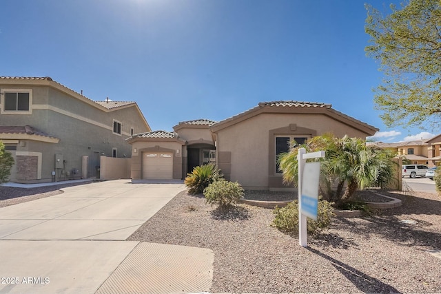 mediterranean / spanish-style house featuring a garage, driveway, a tiled roof, and stucco siding