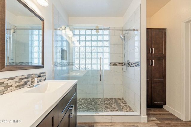 full bathroom featuring a stall shower, vanity, and wood finished floors