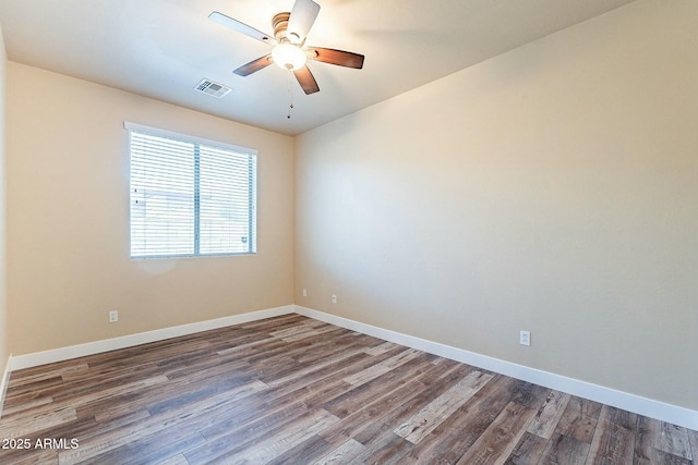 unfurnished room with baseboards, visible vents, ceiling fan, and wood finished floors