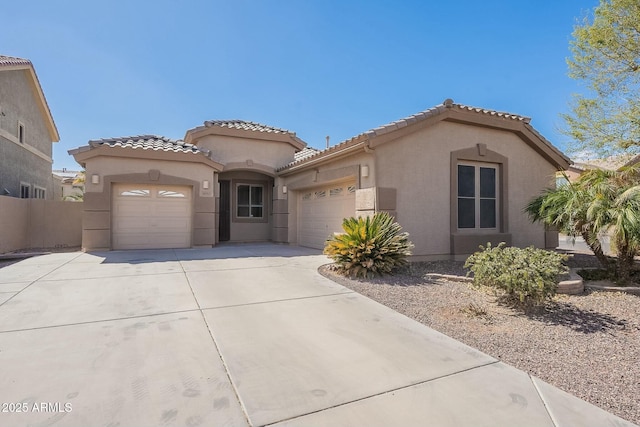 mediterranean / spanish-style house featuring a garage, concrete driveway, a tile roof, and stucco siding