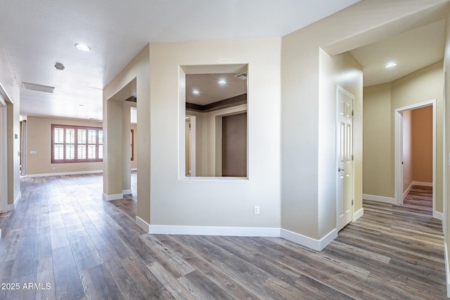 corridor with recessed lighting, visible vents, baseboards, and wood finished floors