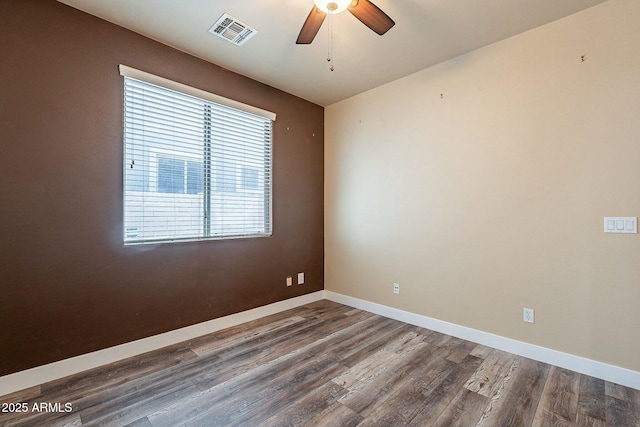 unfurnished room featuring ceiling fan, wood finished floors, visible vents, and baseboards