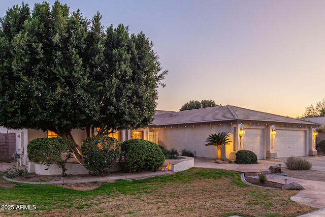 view of front of property featuring driveway, a garage, and stucco siding